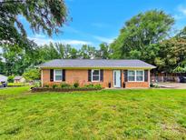 Charming brick home featuring a well-maintained lawn, a welcoming front door, and classic black shutters at 4108 Mellon Rd, Matthews, NC 28104