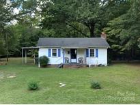 Charming single-story home with blue shutters, a cozy front porch, and a lush, green lawn at 555 Ridge Ave, Mooresville, NC 28115