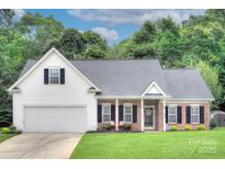 Charming home with a well-manicured lawn, brick accents, and an attached two-car garage at 5748 Timbertop Ln, Charlotte, NC 28215