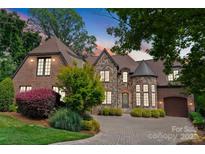Stunning stone and brick home with manicured landscaping and a circular driveway at 5915 Vidal Ln, Charlotte, NC 28226