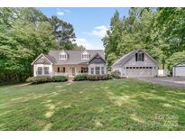 Charming home with a lush front yard, a welcoming porch, and a detached garage at 592 Woodcrest Dr, Gastonia, NC 28056