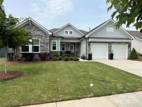 Charming home with stone accents, two-car garage and meticulously maintained lawn at 7057 Kingfisher Way, Belmont, NC 28012