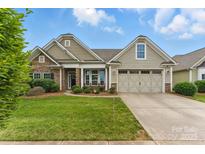 Charming home with a stone facade, well-manicured lawn, and a two-car garage, set beneath a beautiful sky at 8830 Artesa Mill Ln, Charlotte, NC 28214