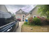 Charming two-story home with vinyl siding, arched front door and blossoming azaleas at 8927 Comstock Ct, Locust, NC 28097