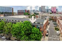 Brick building in urban landscape, with nearby businesses and the city skyline in the background at 115 E Park Ave # 428, Charlotte, NC 28203