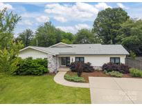 Charming single-story home featuring stone accents, fresh landscaping, and a well-maintained front yard at 1207 Lakedell Dr, Charlotte, NC 28215