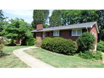 Charming brick home featuring a manicured lawn and inviting walkway at 1245 Paddock Cir, Charlotte, NC 28209