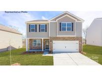 Charming two-story home featuring stone accents, a two-car garage, and a well-manicured lawn at 138 Rustling Waters Dr, Mooresville, NC 28117