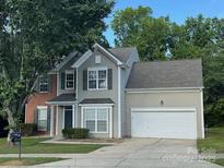 Charming two-story home featuring a combination of brick and siding, complemented by a well-manicured lawn and an attached garage at 152 Hampshire Dr, Mooresville, NC 28115