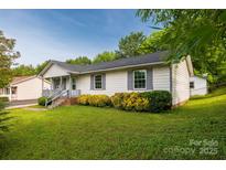 Charming one-story home featuring a well-maintained lawn and colorful landscaping at 1613 Hamilton St, Charlotte, NC 28206
