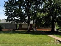 Charming brick home with mature trees and a well-maintained front lawn, creating a welcoming curb appeal at 1821 Beaman St, Shelby, NC 28152