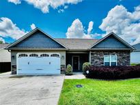Charming single-story home with stone accents, a manicured lawn, and an attached two-car garage at 2021 Chantilly Ln, Salisbury, NC 28146