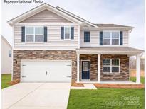Charming two-story home featuring stone accents, blue shutters, a two-car garage, and a well-maintained lawn at 221 Paige Rd, Kings Mountain, NC 28086