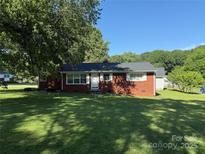 Charming brick home featuring a well-manicured lawn and mature trees, offering a welcoming curb appeal at 2601 Marldale St, Gastonia, NC 28052