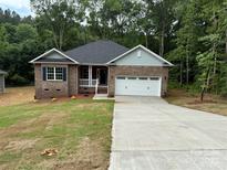 Charming brick home with a well-manicured lawn, attached garage, and inviting front porch at 2915 Noritake Trl # 71, Albemarle, NC 28001