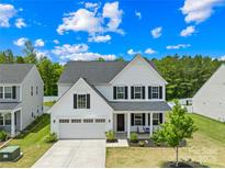 Charming two-story home featuring a two-car garage and a welcoming front porch at 3110 Streamside Dr, Davidson, NC 28036