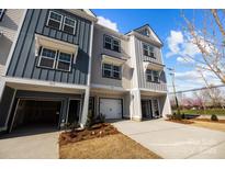 Charming townhome exterior showcases a two-car garage, and a well-manicured front yard with fresh landscaping at 3124 Butler Hill Dr, Matthews, NC 28105