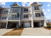 A row of modern townhomes featuring eye-catching facades and attached garages, creating an inviting neighborhood street view at 3128 Butler Hill Dr, Matthews, NC 28105