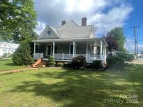 Charming home featuring a cozy front porch, mature landscaping, and a well-maintained lawn at 328 E Center Ave, Mooresville, NC 28115