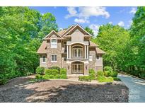 Stunning stone and stucco home with manicured landscaping and a circular driveway at 335 Whisper Lake Dr, New London, NC 28127