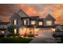 Charming two-story home featuring a manicured lawn, attached two car garage, and a covered front porch at 4023 Spring Garden St, Fort Mill, SC 29715