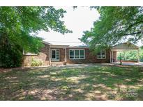 Charming brick home with mature trees and a covered carport offers a welcoming facade and ample outdoor space at 4268 Wilkesboro Hwy, Statesville, NC 28625
