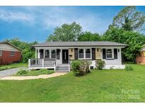 Charming single-story house with a well-manicured lawn and inviting front porch at 4914 Ridgeley Dr, Charlotte, NC 28208