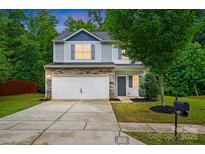 Charming two-story home boasts stone accents, a two-car garage, and a well-maintained front yard at 6322 Sydney Mae Ln, Charlotte, NC 28262
