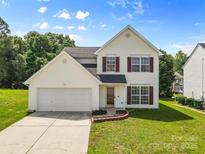 Charming two-story home featuring a well-maintained lawn, attached garage, and inviting curb appeal at 7212 Ravanna Dr, Charlotte, NC 28213