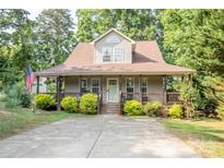 Charming home with a covered front porch, manicured lawn, and a long drive way at 7691 Red Robin Trl, Denver, NC 28037
