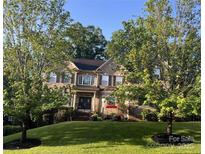 Charming two-story brick home with mature trees and a well-manicured lawn in a desirable neighborhood at 9913 Hazelview Dr, Charlotte, NC 28277