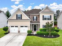 Charming two-story home featuring a well-manicured lawn, a two-car garage, and a welcoming front entrance at 1033 Crawford Dr, Indian Land, SC 29720