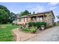 Charming single-story home with a stone walkway and lush landscaping at 112 Gays Chapel Rd, Statesville, NC 28625