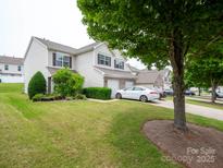Inviting townhome featuring an attached garage, well-maintained lawn, and mature landscaping in a desirable neighborhood at 12222 Stratfield Place Cir, Pineville, NC 28134