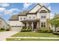 Charming two-story home with a landscaped yard and a welcoming front porch at 14228 Twin Eagles Ln, Charlotte, NC 28278