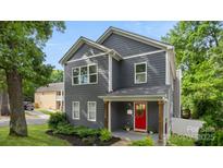 Charming two-story home with gray siding, a bright red door, and a welcoming front porch at 1446 Downs Ave, Charlotte, NC 28205