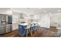 Modern kitchen featuring a large island with seating, stainless steel appliances, and hardwood floors at 1446 Downs Ave, Charlotte, NC 28205