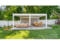 Cozy outdoor patio area with stylish seating, dining area, and ambient string lights for evening relaxation at 1446 Downs Ave, Charlotte, NC 28205