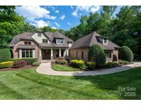 Charming brick home with manicured lawn, lush landscaping, and inviting walkway at 1500 Tarrington Way, Wesley Chapel, NC 28079