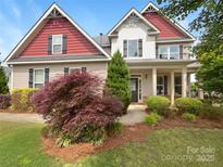 Charming two-story home featuring a well-manicured lawn, lush landscaping, and inviting entrance at 178 Wellshire St, Mooresville, NC 28115