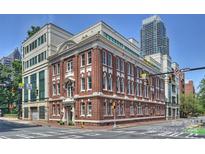 Beautiful multi-story brick building featuring white trim, large windows, and prime corner lot placement near downtown at 229 N Church St # 204, Charlotte, NC 28202