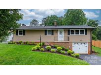 Charming single-story home featuring lush landscaping and a welcoming front entrance at 2401 Hillside Dr, Newton, NC 28658