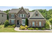 Beautiful two-story stone home with manicured landscaping and charming architectural details at 2414 Madeira Cir, Waxhaw, NC 28173