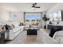 Bright living room features a large sectional sofa, decorative ceiling fan, and contemporary furnishings at 3110 Stelfox St, Charlotte, NC 28262