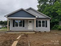 Charming single-story home with gray siding, black shutters, and a covered front porch, ready for landscaping at 528 S Caldwell St, Salisbury, NC 28144