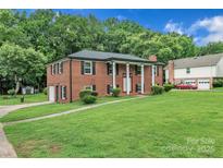 A charming two-story red brick home boasts a beautiful lawn and well-maintained landscaping at 5633 Mallard S Dr, Charlotte, NC 28227