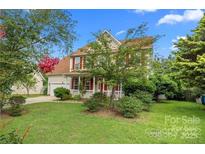 Charming two-story home featuring a well-manicured lawn, red shutters, and a welcoming front porch at 6614 Truman St, Indian Trail, NC 28079
