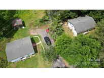 This aerial view showcases multiple homes on a lush lot, plus an detached outbuilding at 6649 Mountain Grove Rd, Hickory, NC 28602