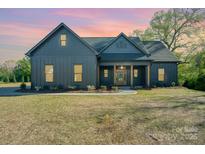 Charming single Gathering home featuring a craftsman style elevation, well manicured lawn and inviting front porch at 919 Village Lake Dr, Monroe, NC 28110