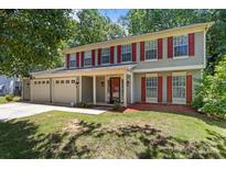 Charming two-story home with red shutters, vinyl siding, a covered porch and a two-car garage at 10327 Shelter Rock Ct, Charlotte, NC 28214